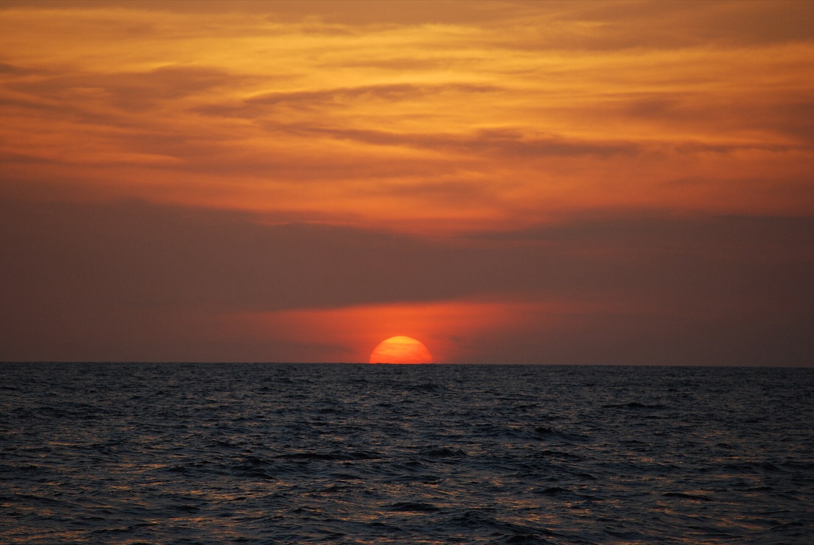 The sun setting over the sea at Playas del Coco