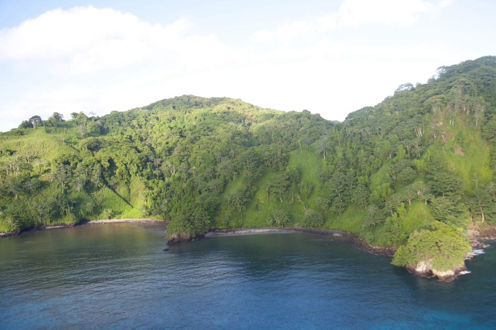 Forested cliffs and a sheltered cove at Cocos Island